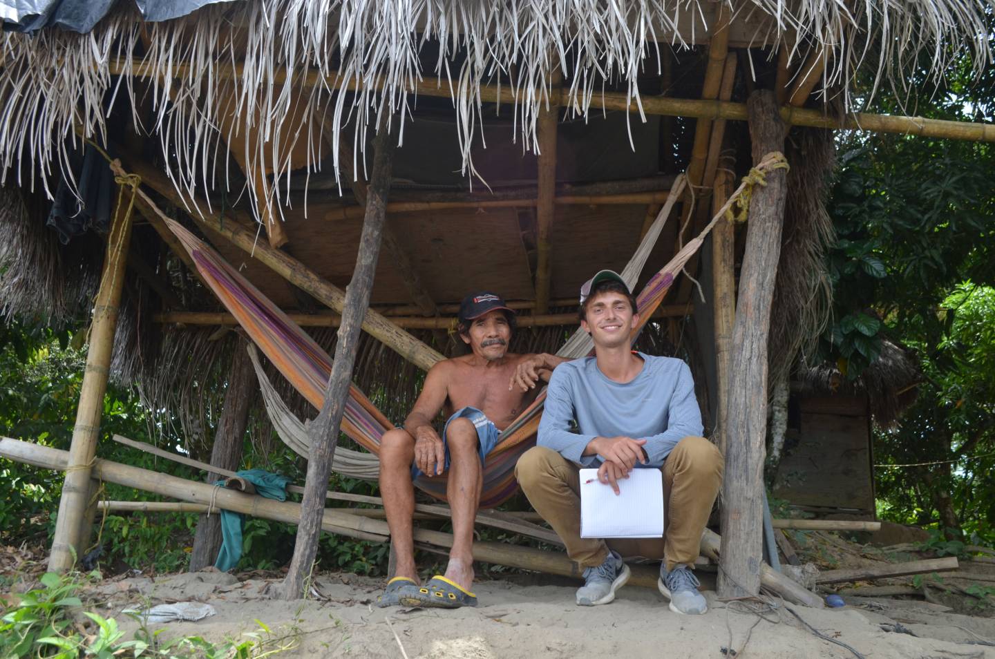Jordan Salama sits with a man next to a hammock